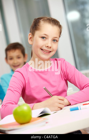 Porträt von smart Schulmädchen Notizen und Blick in die Kamera Stockfoto