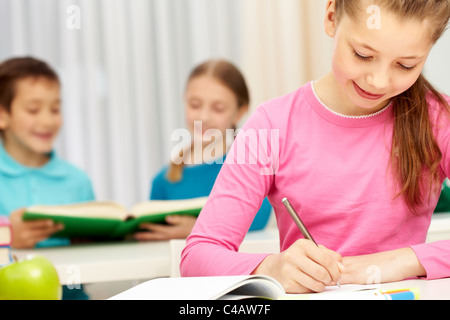 Porträt von smart Schulmädchen Notizen in ihrem Schulheft Stockfoto