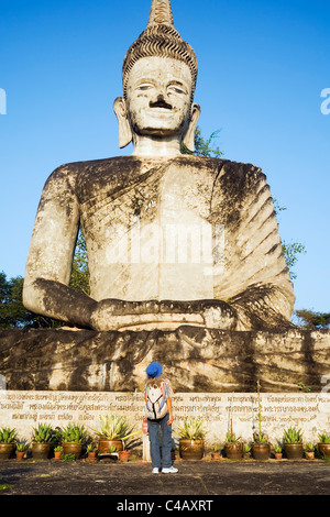 Thailand, Nongkhai, Nong Khai. Ein Tourist schaut zu einer riesigen Skulptur in der Sala Kaew Ku Sculpture Park. Stockfoto