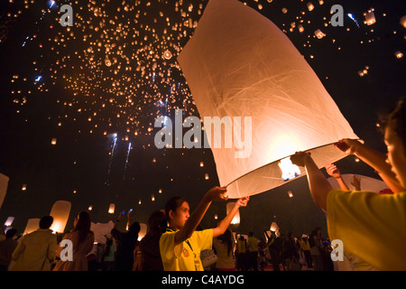 Thailand, Chiang Mai, San Sai.  Nachtschwärmer starten während der Yi Peng Festival Khom Loi (Himmelslaternen) in den Nachthimmel. Stockfoto
