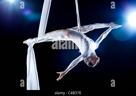Junge Frau Turnerin. Auf schwarzem Hintergrund mit Flash-Effekt. Stockfoto