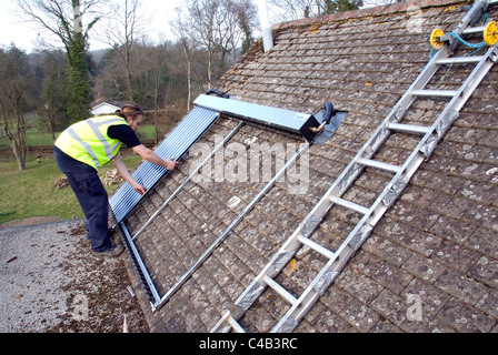 Ingenieure, die Installation solar thermische evakuierten Röhre Array auf dem Dach eines inländischen Hauses Erneuerbare Wärme und Warmwasser Stockfoto