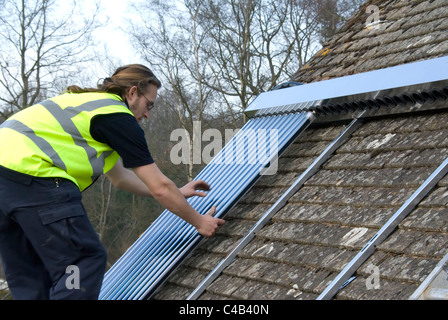 Ingenieure, die Installation solar thermische evakuierten Röhre Array auf dem Dach eines inländischen Hauses Erneuerbare Wärme und Warmwasser Stockfoto