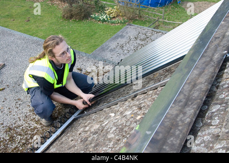 Ingenieure, die Installation solar thermische evakuierten Röhre Array auf dem Dach eines inländischen Hauses Erneuerbare Wärme und Warmwasser Stockfoto