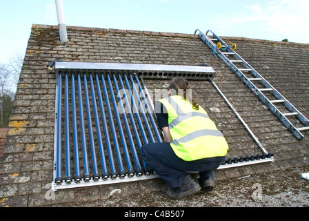 Ingenieure, die Installation solar thermische evakuierten Röhre Array auf dem Dach eines inländischen Hauses Erneuerbare Wärme und Warmwasser Stockfoto