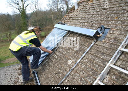 Ingenieure, die Installation solar thermische evakuierten Röhre Array auf dem Dach eines inländischen Hauses Erneuerbare Wärme und Warmwasser Stockfoto