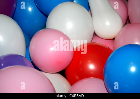 Eine Feier mit vielen bunten Luftballons hängen an der Decke oder auf dem Boden, ideal für eine Kinder-Geburtstags-Party. Stockfoto
