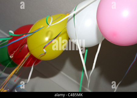 Eine Feier mit vielen bunten Luftballons hängen an der Decke oder auf dem Boden, ideal für eine Kinder-Geburtstags-Party. Stockfoto