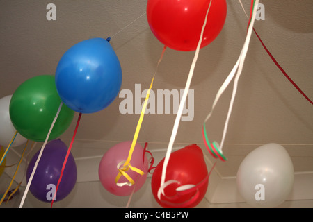 Eine Feier mit vielen bunten Luftballons hängen an der Decke oder auf dem Boden, ideal für eine Kinder-Geburtstags-Party. Stockfoto