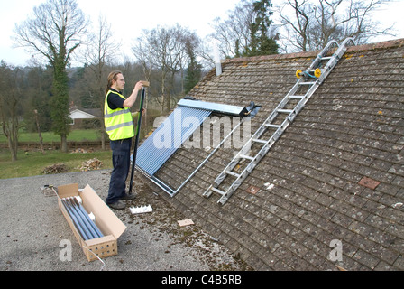 Ingenieure, die Installation solar thermische evakuierten Röhre Array auf dem Dach eines inländischen Hauses Erneuerbare Wärme und Warmwasser Stockfoto