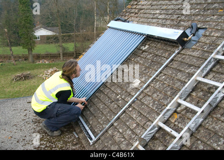 Ingenieure, die Installation solar thermische evakuierten Röhre Array auf dem Dach eines inländischen Hauses Erneuerbare Wärme und Warmwasser Stockfoto