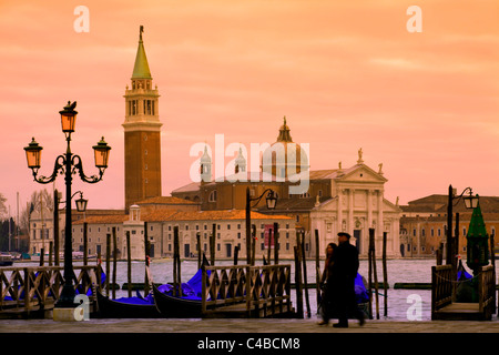 Venedig, Veneto, Italien; Ein paar zu Fuß auf dem Bacino di San Marco zuschauenden San Giorgio Maggiore Stockfoto