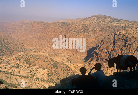 Jordan, Dana Biosphere Reserve. Dana Dorf Jugendliche blicken Sie über die spektakulären Lippe des Wadi Dana in Richtung Feynan. Stockfoto