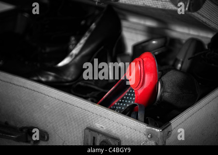 Farbbild tauchte der Damenschuhe in old fashioned Armee Demob Koffer mit roten Schuh in Farbe Stockfoto