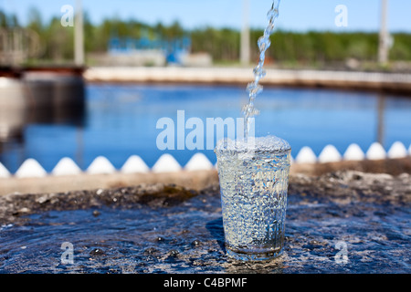 Glas mit Flüssigkeit fließen in einer Wasseraufbereitungsanlage Stockfoto