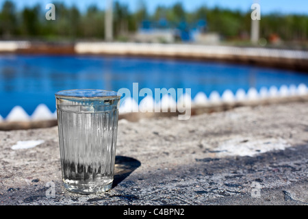 Glas mit Flüssigkeit fließen in einer Wasseraufbereitungsanlage Stockfoto