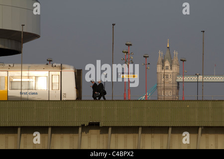 London-Pendler Fuß zum erstklassigen Zug auf London Cannon Street Station Eisenbahnbrücke mit Tower Bridge im Hintergrund Stockfoto