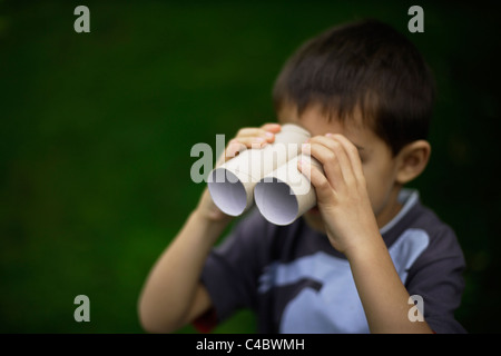 Sechs Jahre alter Junge Toilette Pappröhren aus Toilettenpapier verwendet rollt wie Fernglas. Gemischte Rassen, indischen ethnischen kaukasischen Stockfoto
