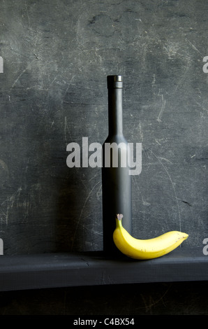 Stilleben mit Flasche und Banane schwarz Stockfoto