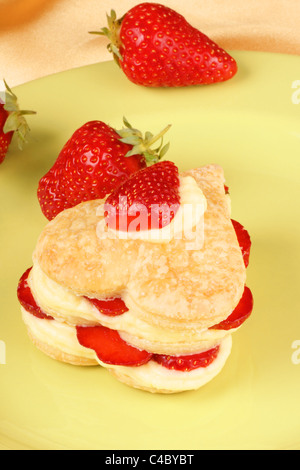 Herzförmige, Erdbeeren und Creme Millefeuille auf einer grünen Platte. Für einen süßen Valentinstag. Selektiven Fokus. Stockfoto