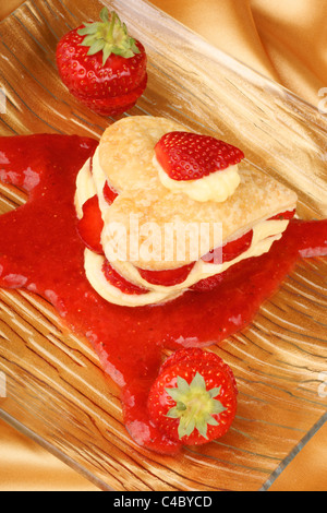 Herzförmige, Erdbeeren und Creme Millefeuille auf Erdbeersauce. Für einen süßen Valentinstag. Selektiven Fokus. Stockfoto