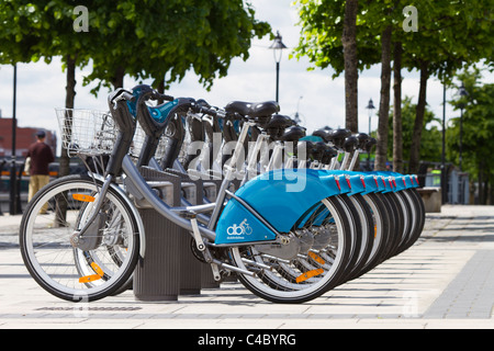 Eine Reihe von Dublin Fahrräder zu vermieten auf dem Georges Quay, Dublin. Ein Passant von kann im Hintergrund zu sehen. Stockfoto