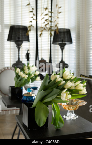 Reihe von Tulpen in einer schwarzen quadratischen Vase mit Spiegelbild Stockfoto