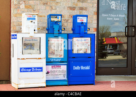 Verkaufsautomaten Zeitung Boxen für die wichtigsten Chicago Tageszeitungen sitzen außerhalb einer geschlossenen Restaurant. Bartlett, Illinois, USA. Stockfoto