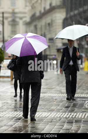London City Arbeitnehmer im Regen mit Sonnenschirmen in Queen Street, London, UK. Stockfoto
