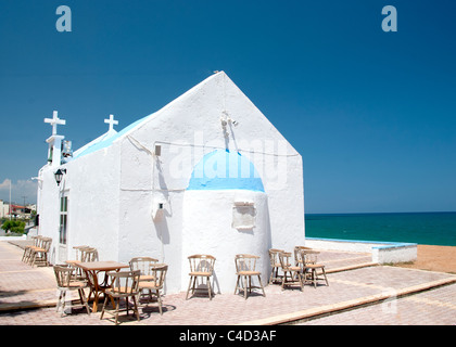 Eine ziemlich griechisch-orthodoxe Kirche auf einer Landzunge auf Kreta mit dem Ägäischen Meer im Hintergrund beliebt für Hochzeiten im freien Stockfoto