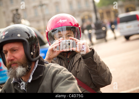 Ein Tourist nimmt ein Bild von ihrem Motorrad auf der Mall am Abend vor der Hochzeit von Prinz William und Kate Middleton Stockfoto