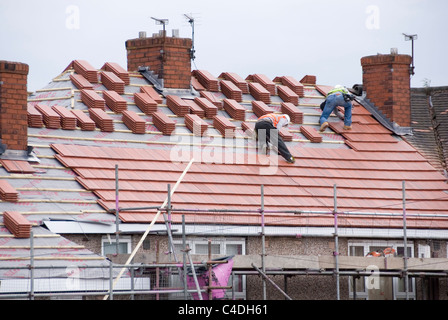 Zwei Männer auf dem Dach des Hauses legen neue Dachziegel auf drei benachbarten Eigenschaften, ACIS Re Überdachung, Hastilar Straße nach Süden, Sheffield Stockfoto