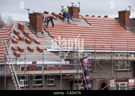 Drei Männer am Dach des Hauses legen neue Dachziegel, Re Überdachung ACIS Eigenschaften, Hastilar Straße nach Süden, Sheffield, März 2011 Stockfoto