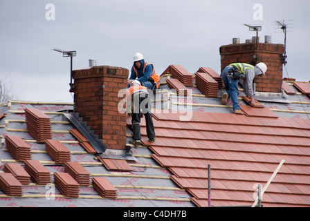 Drei Männer am Dach des Hauses legen neue Dachziegel, Re Überdachung ACIS Eigenschaften, Hastilar Straße nach Süden, Sheffield, März 2011 Stockfoto