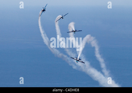 Die Extra Kunstflug Flugzeug der klingen bei Bildung über das Meer in Gibraltar Stockfoto