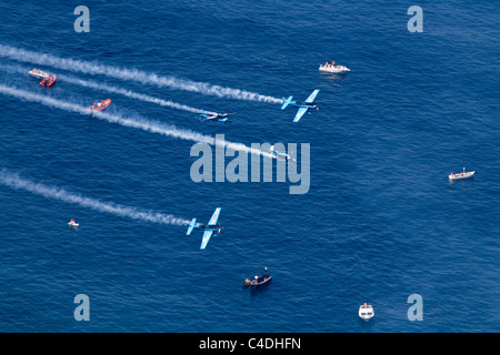 Die Extra Kunstflug Flugzeug der klingen bei Bildung über das Meer in Gibraltar Stockfoto