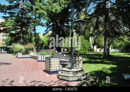 Sonnigen rot Mosaik Fliesen Weg mit weißen blauen Mosaik Fliesen Garten Blume Betten grüne Grasbäume, Plaza Espana, Mendoza, Argentinien Stockfoto