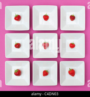 Erdbeeren im Quadrat keramisches Geschirr auf einem rosa Hintergrund Stockfoto