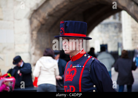 Ein Yeoman Warder, beaufsichtigt Sicherheit am touristischen Eingang in den Tower of London, London, UK Stockfoto