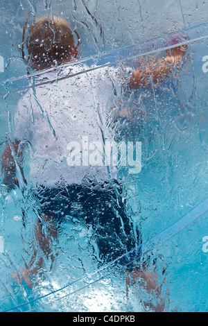 Kinder im Wasser Walkerz Aufblasbarer Aqua Bubble Ball.Transparenter Ball voller Spaß im Royal Cornwall Showground 2011 Events & Exhibits, Wadebridge, Cornwall County, UK Stockfoto