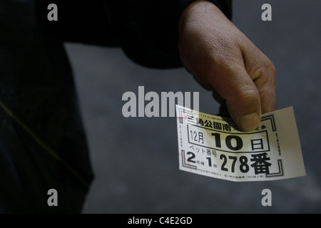 Arbeitslose, Obdachlose Männer, einen Unterschlupf für die Nacht, im Bereich "Arbeitsmarkt Tag" des Kamagasaki, Osaka, Japan gehen. Stockfoto