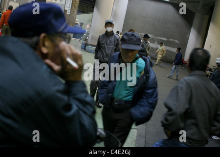 Arbeitslose, Obdachlose Männer, einen Unterschlupf für die Nacht, im Bereich "Arbeitsmarkt Tag" des Kamagasaki, Osaka, Japan gehen. Stockfoto