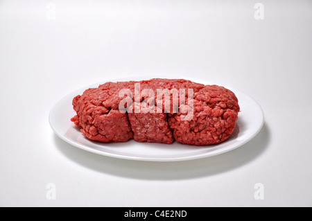 Ein Pfund Hackfleisch sitzt auf eine Untertasse auf weißem Hintergrund Stockfoto