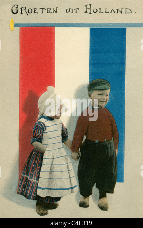 Alte Ansichtskarte malte, jungen und Mädchen in Tracht tragen Holzschuhe 'Groeten Uit Holland' - Grüße aus Holland DEL49 Stockfoto