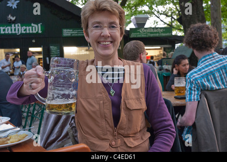 Ein weiblicher Touristen trinkt aus einer sehr großen Bierkrug im Biergarten Augustiner-Keller in München. Stockfoto