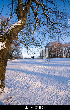 Zwei Menschen, die zu Fuß in ein Schnee bedeckt Park in Preston, England, UK Stockfoto