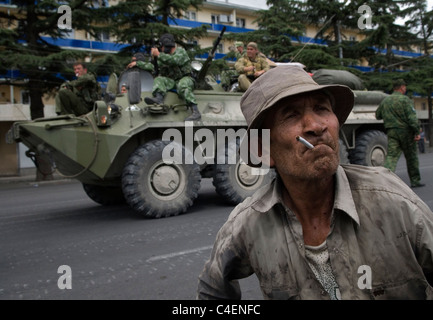 Ein georgischer Zivilist neben einem mit russischen Truppen beladenen APC in der Stadt Gori während des russisch-georgischen Krieges im August 2008 Stockfoto