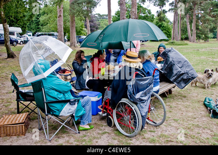 Großfamilie mit einem Picknick in einem Park im Regen Stockfoto