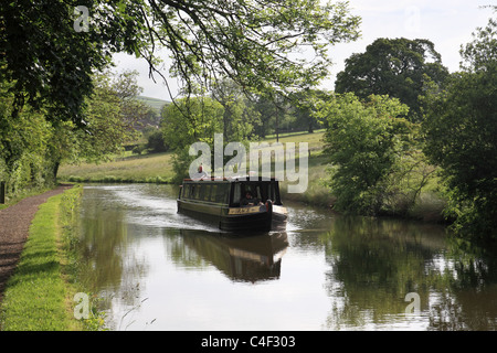 Ein Kanal Narrowboat gleitet entlang der Leeds und Liverpool Kanal in der Nähe von Skipton am Leeds und Liverpool Kanal. Stockfoto