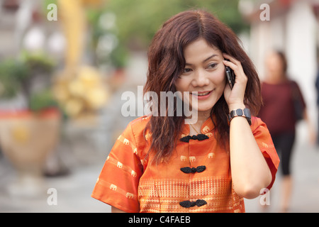 asiatische Frau in traditioneller Kleidung zu telefonieren Stockfoto